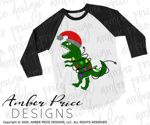 Dinosaur with Christmas lights SVG PNG DXF | Kid's Christmas shirt SVG | Christmas T-Rex SVG SVG Amber Price Design 